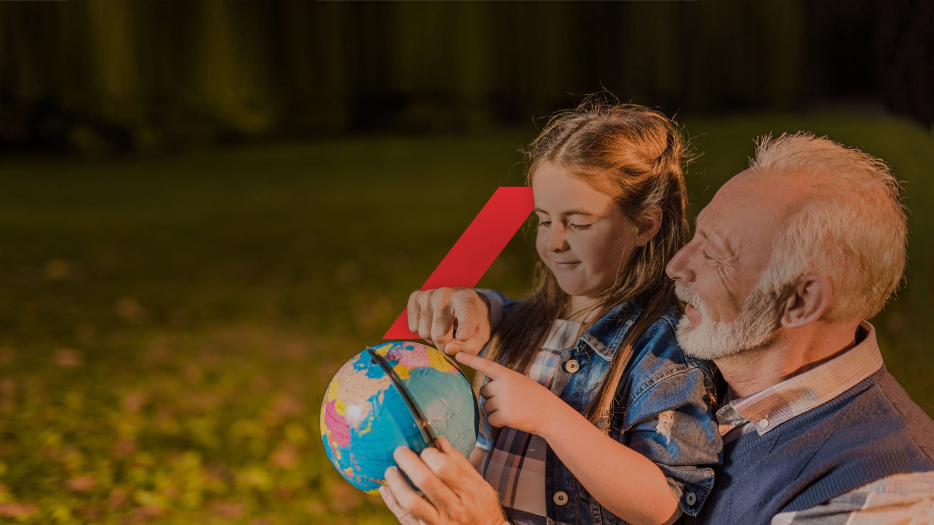 Grandfather and granddaughter looking at globe