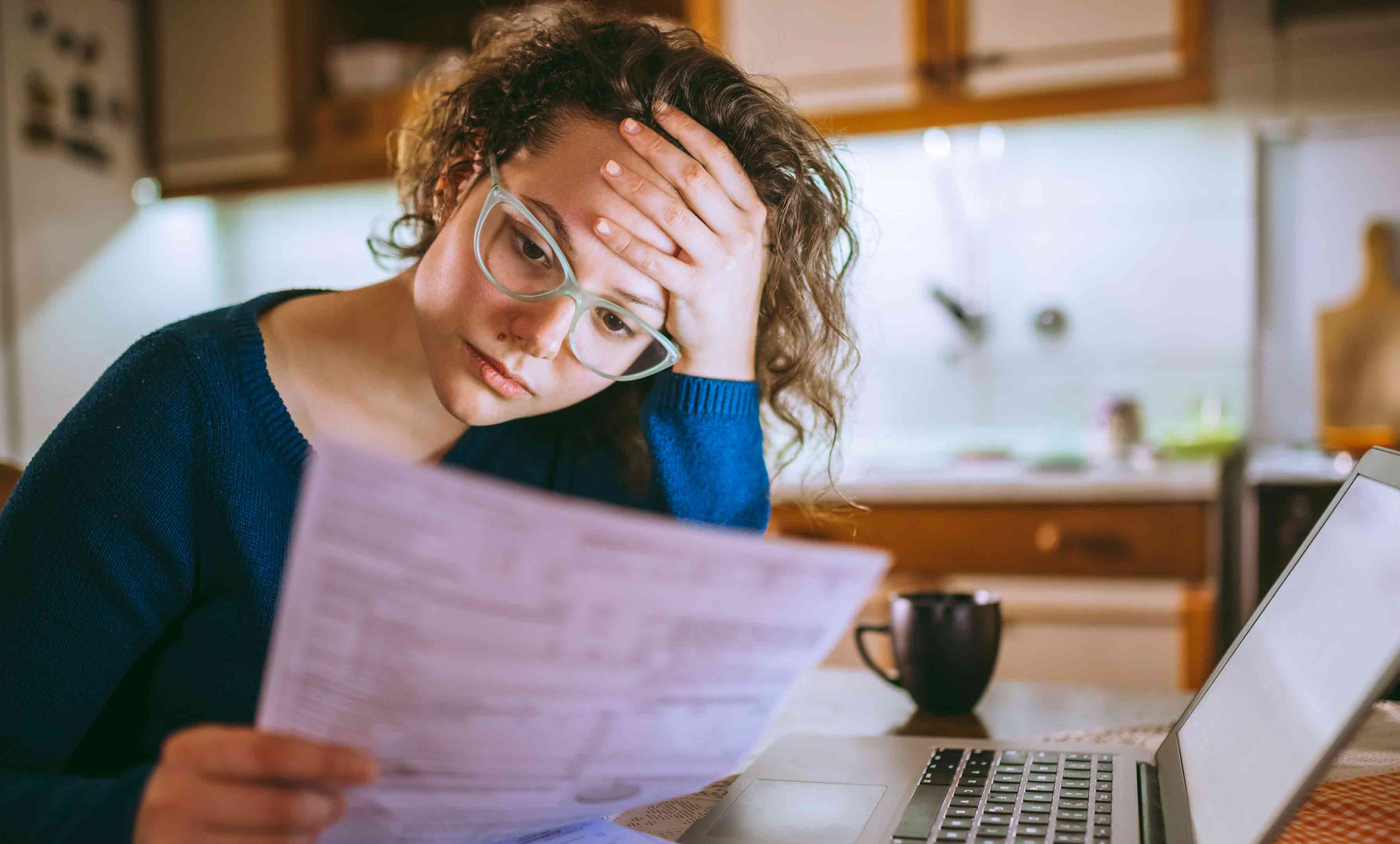 bespectacled-woman-looking-worriedly-at-papers