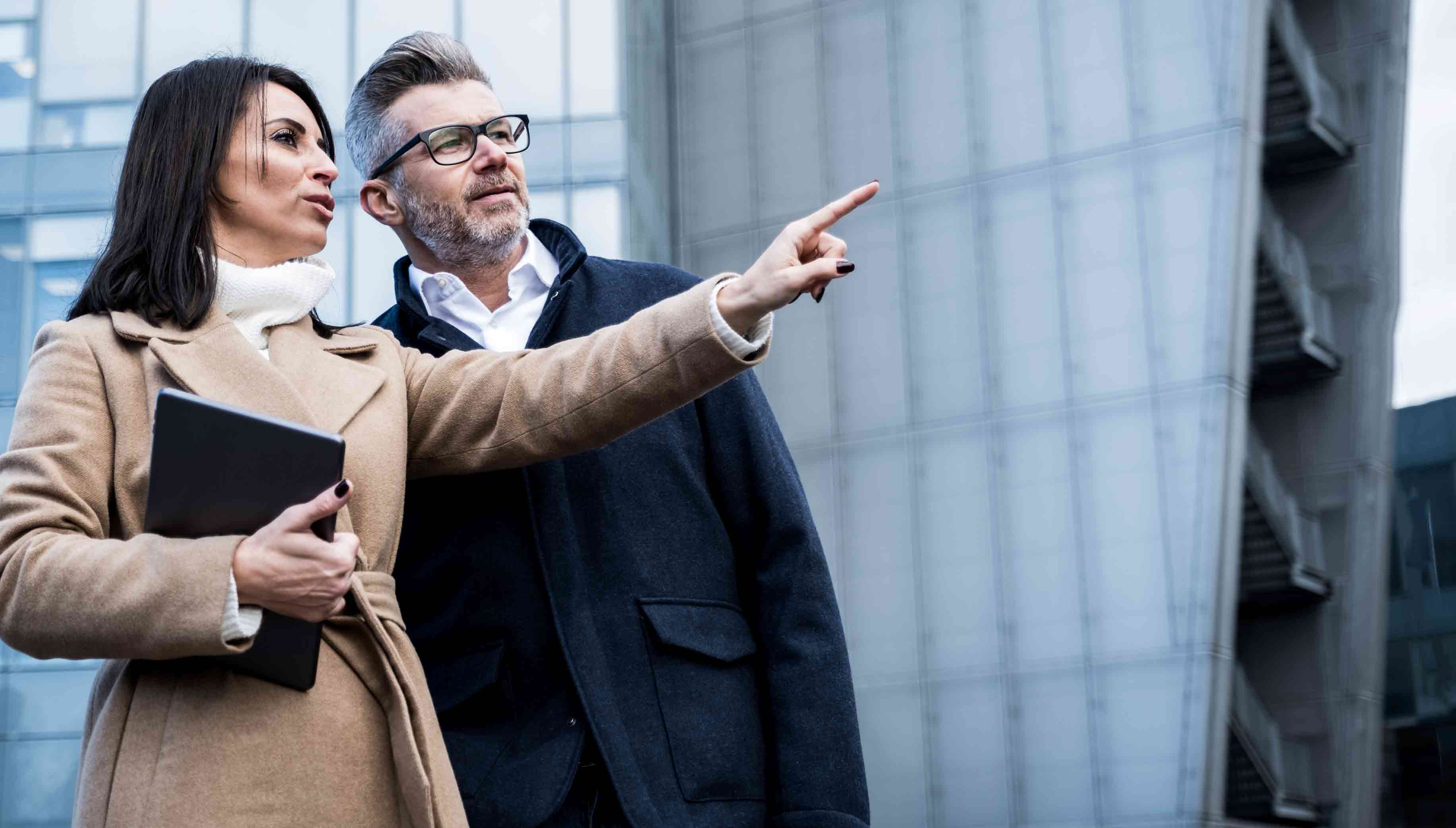 business-woman-pointing-to-distance-as-businessman-looks-on