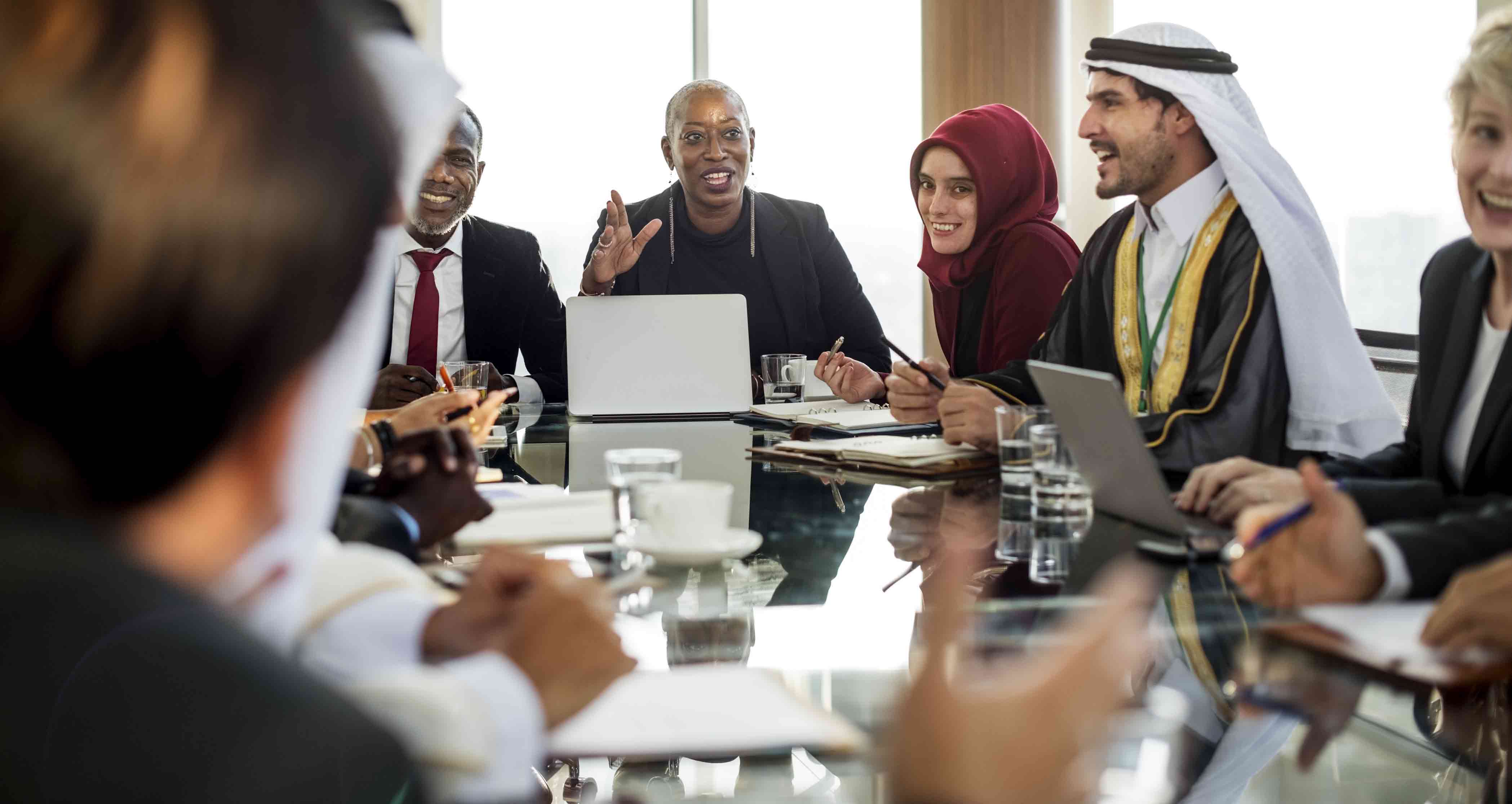 diverse-group-sitting-around-conference-table-smiling