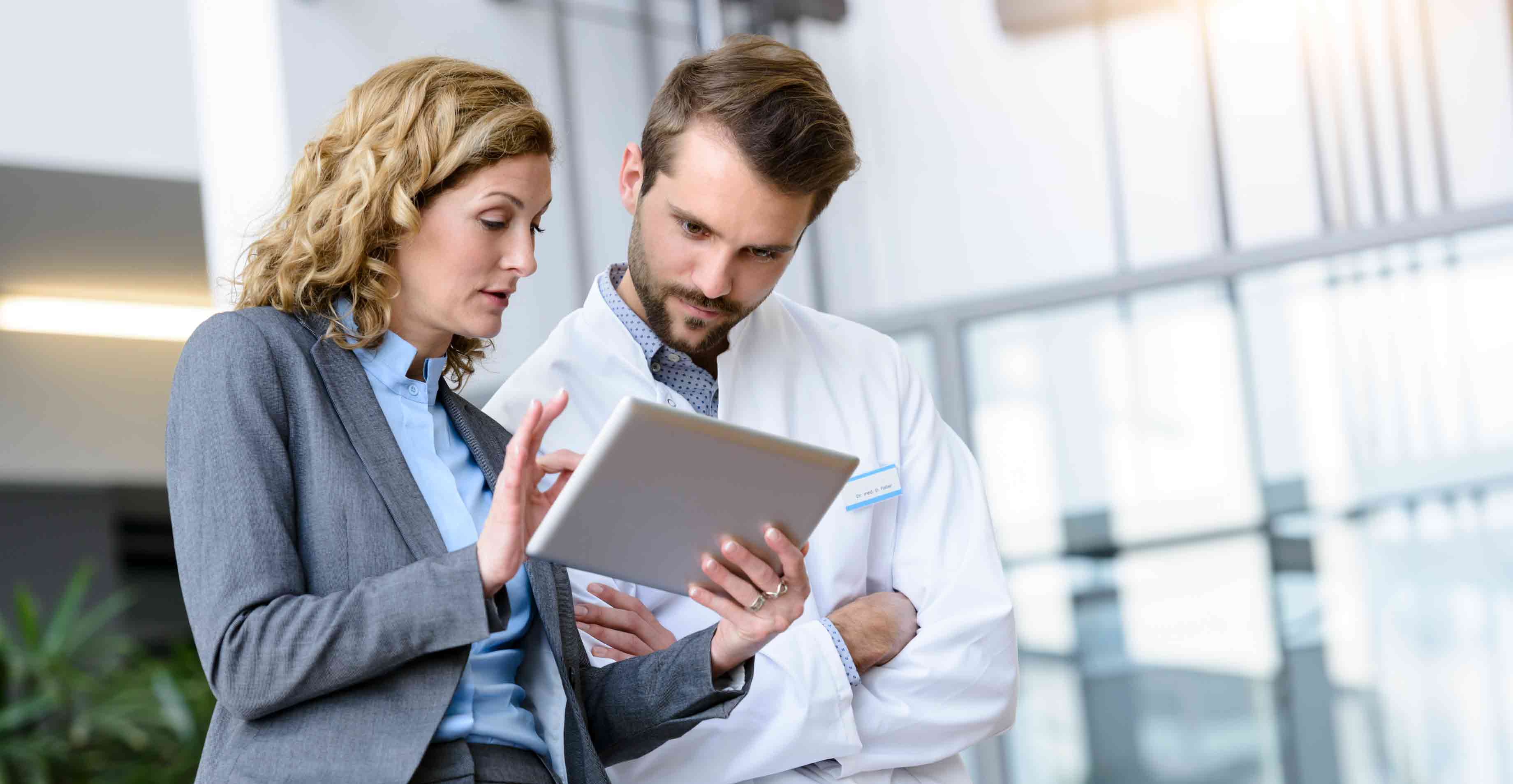 Doctor-and-employee-discussing-over-a-tablet