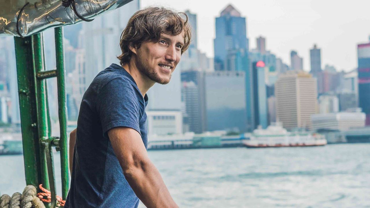 Man-looking-out-from-boat-with-skyline-in-the-background