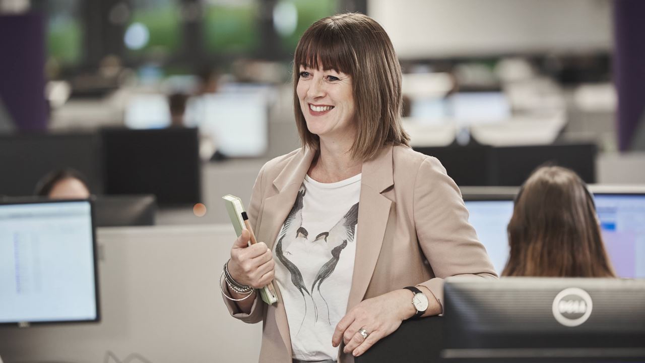 AXA employee in the office smiling.