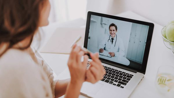 Woman speaking to doctor through laptop