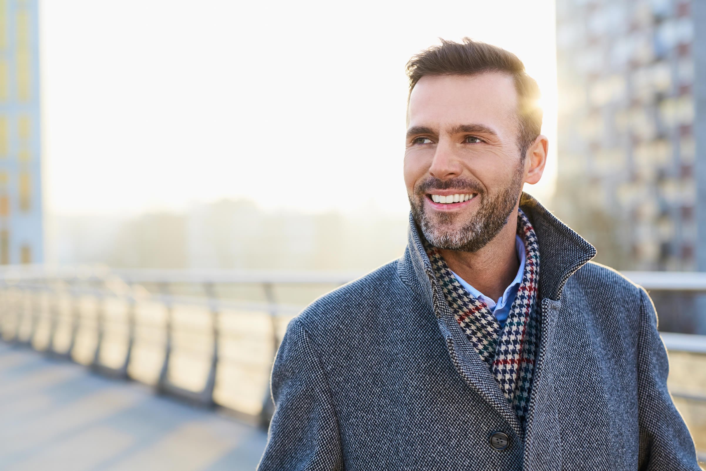 Smiling businessman walking across bridge
