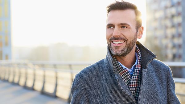 Smiling businessman walking across bridge