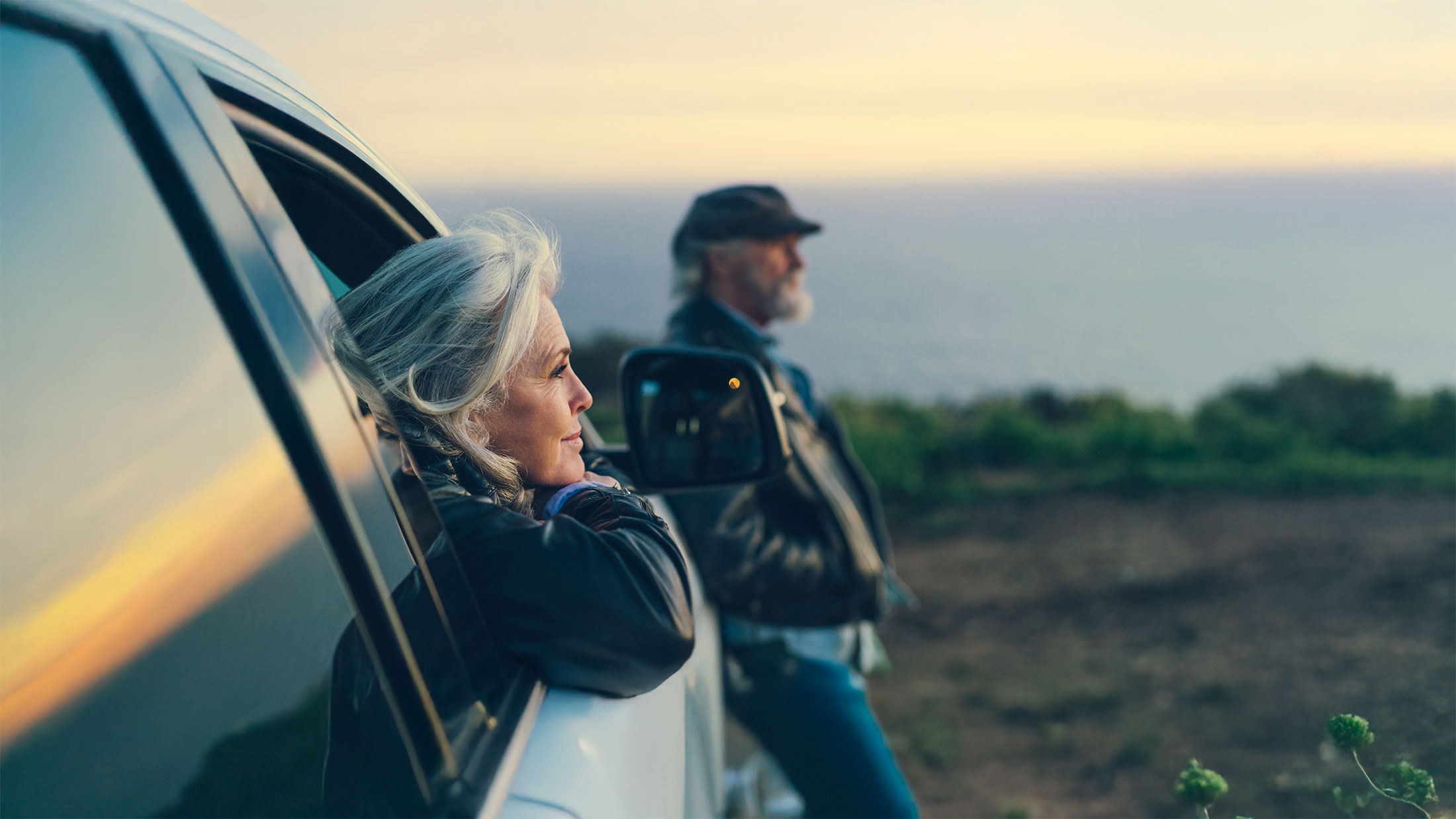 Mature woman sitting in car during sunset