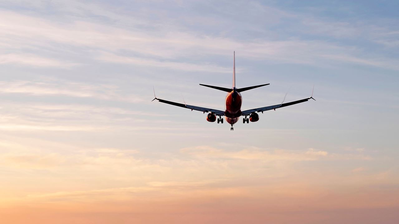 Plane flying off into sunset