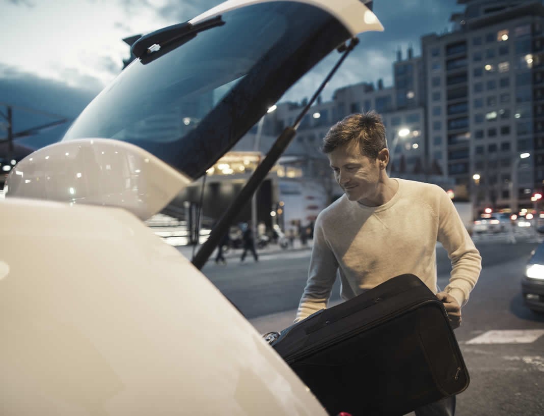 man loading luggage into car