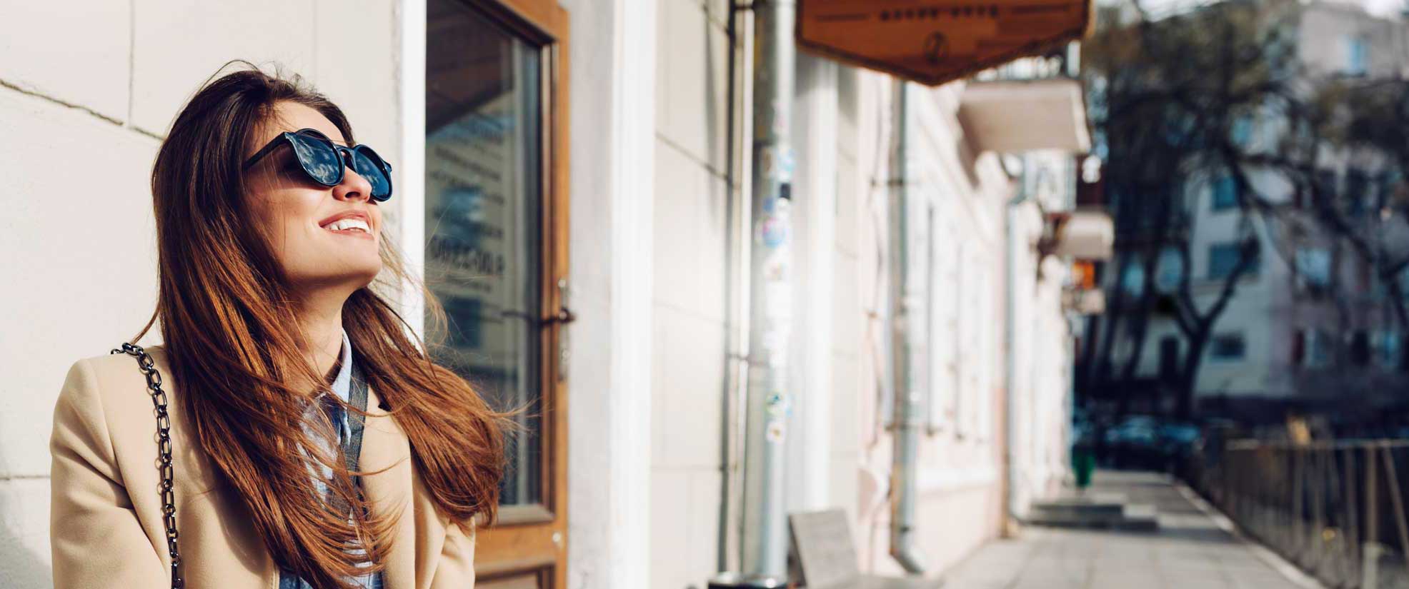 Woman in sunglasses smiling in her new city