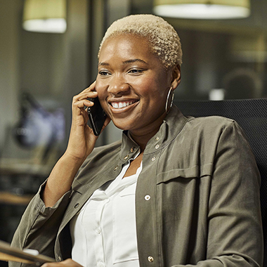 woman smiles whilst talking on phone