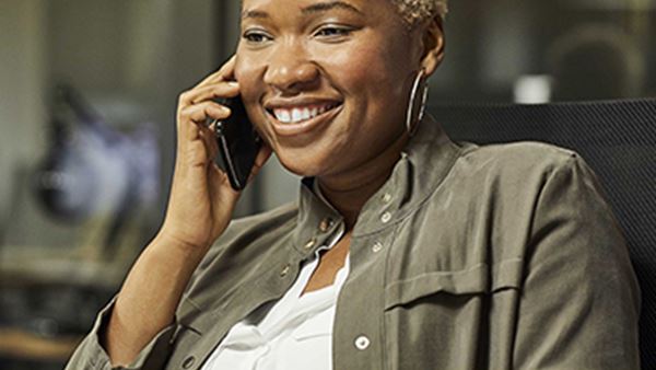 woman smiles whilst talking on phone