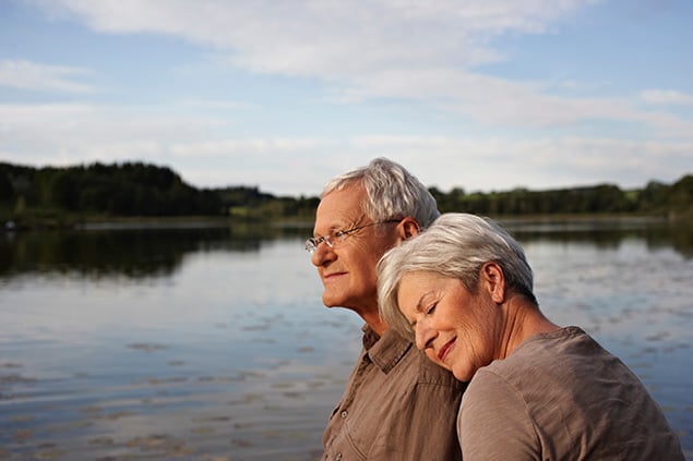 Elderly couple embracing outside