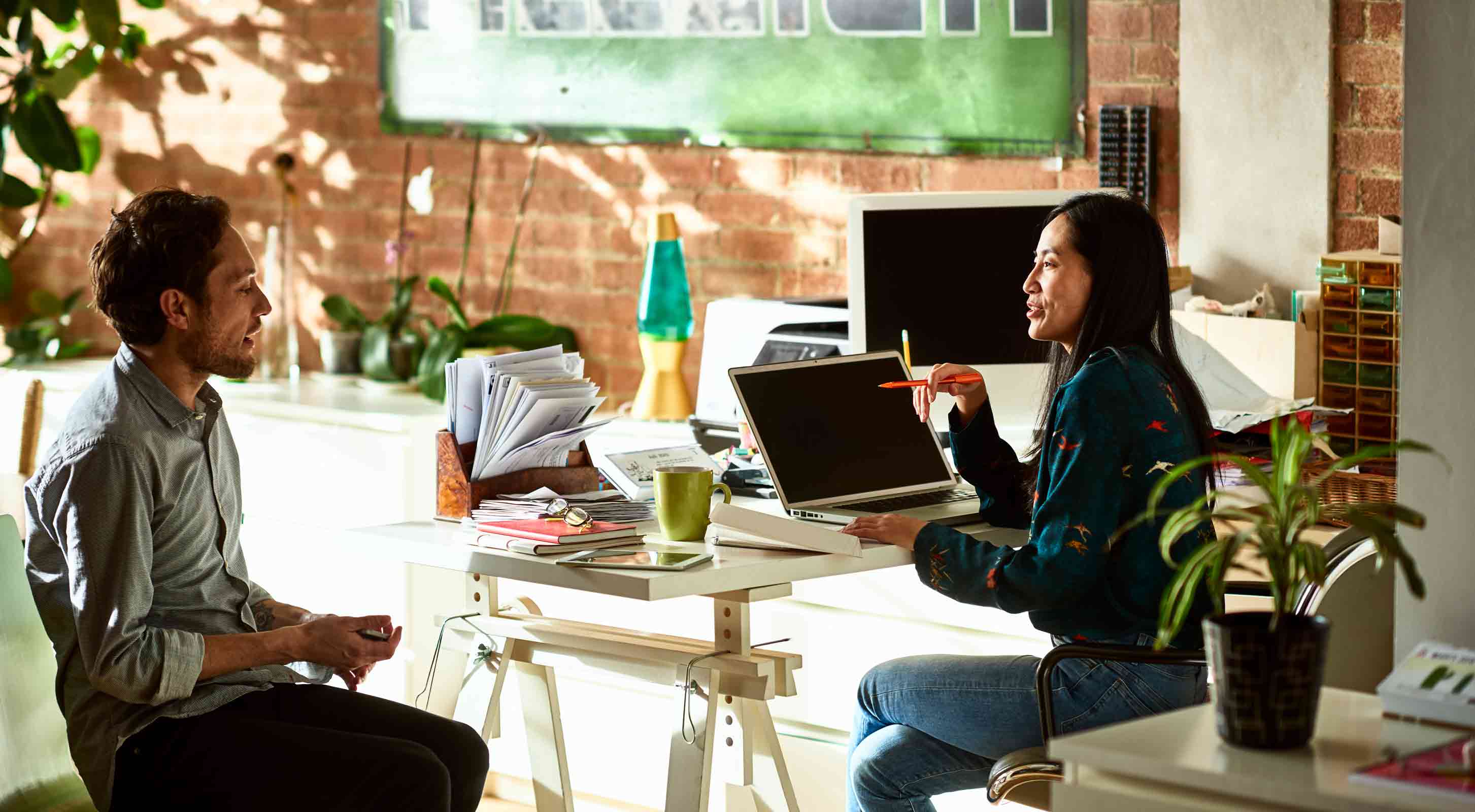 man and woman speaking in vibrant office