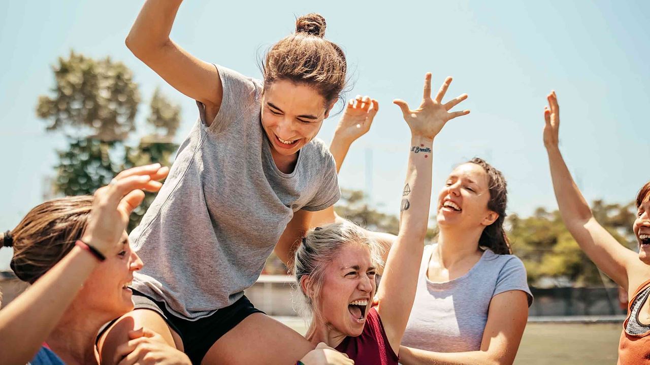 sportswomen celebrating a team member