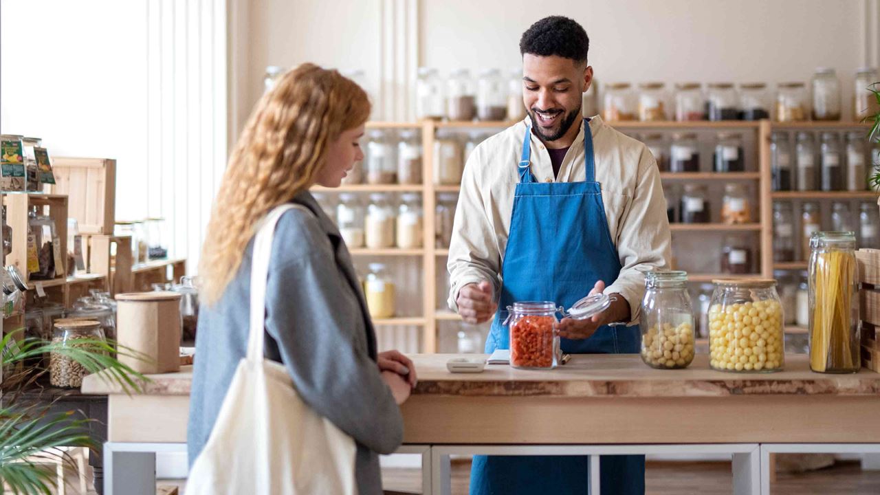customer-being-helped-by-happy-clerk-at-produce-shop