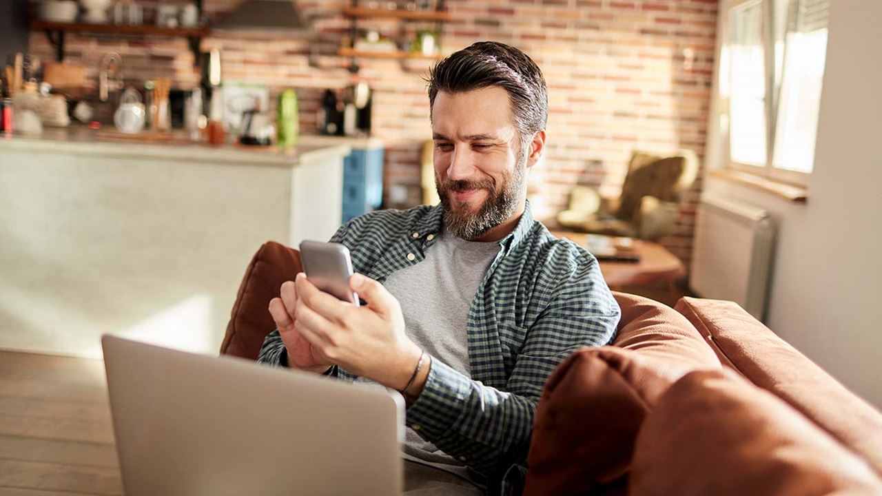 man on sofa working on laptop