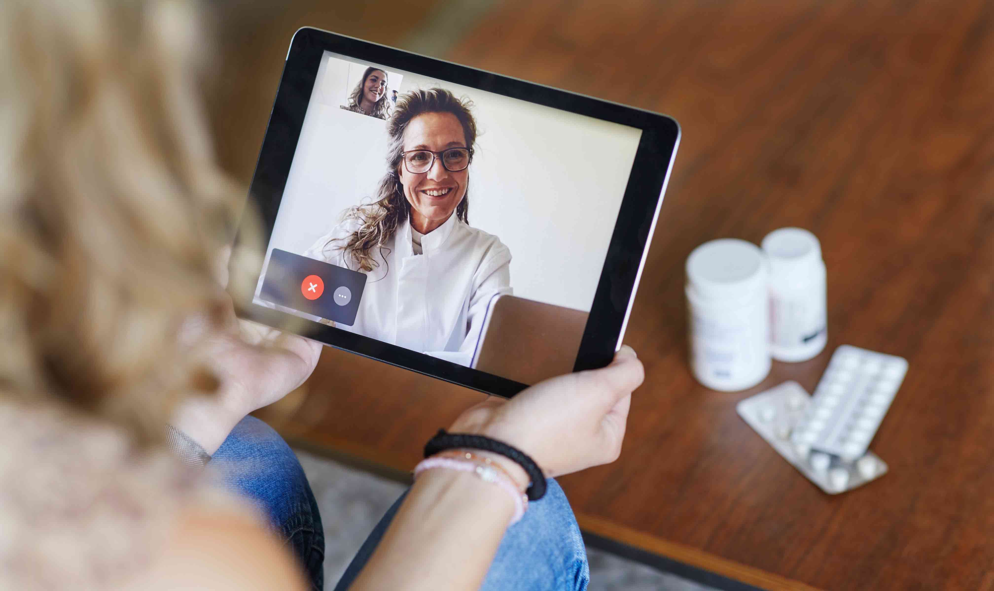 Woman consulting virtual doctor on tablet