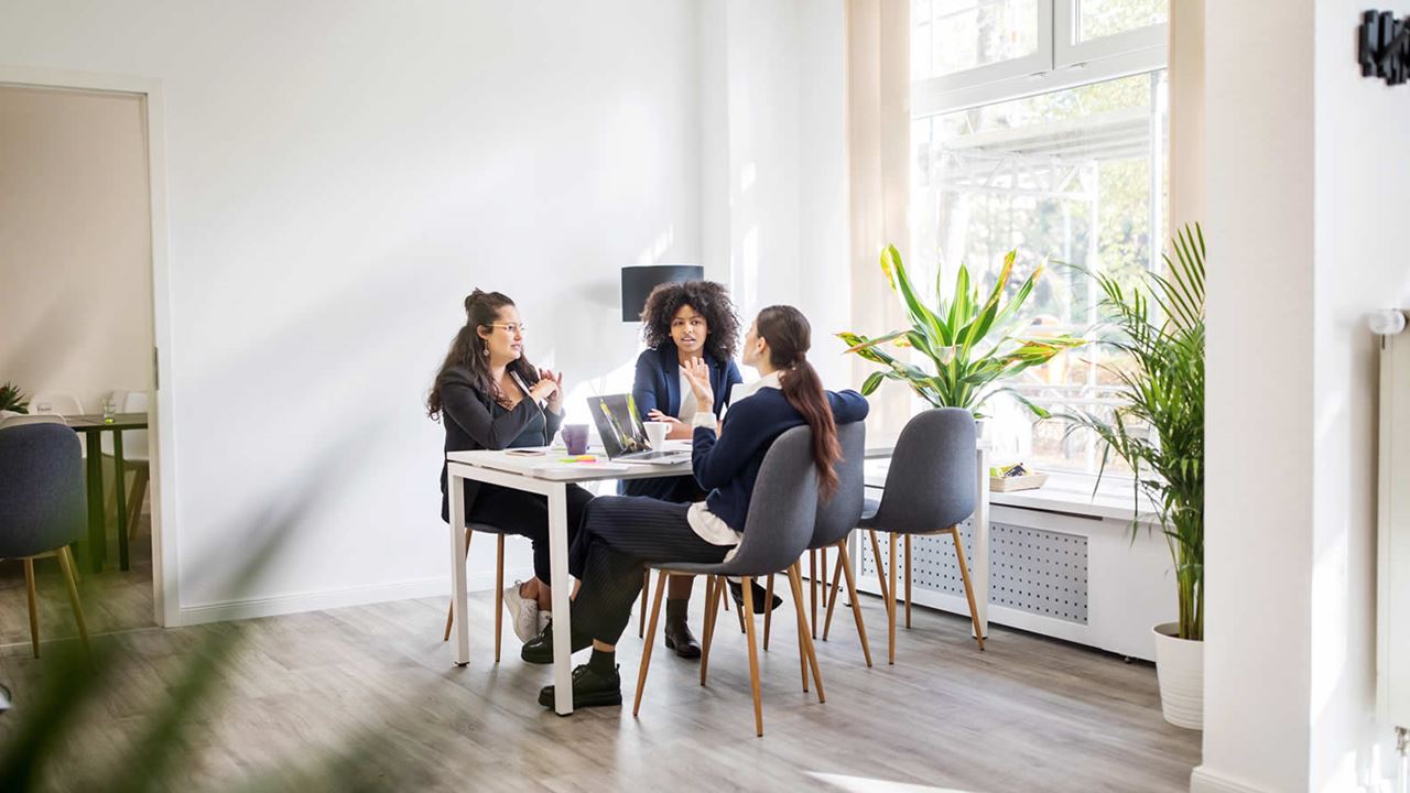 Three businesswomen having a meeting round a table