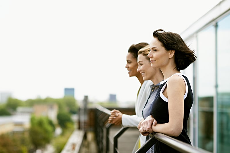 Three women looking outside the balcony