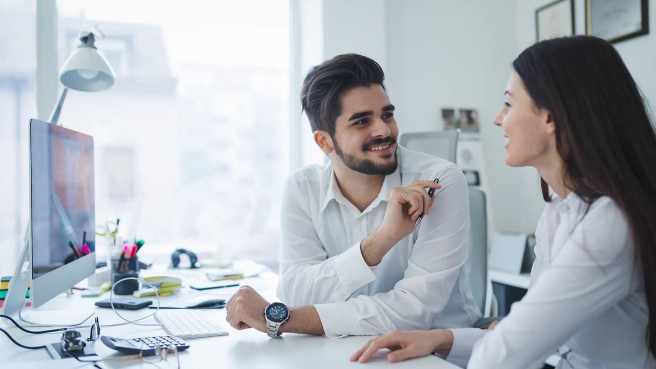 Work colleagues chatting at desk