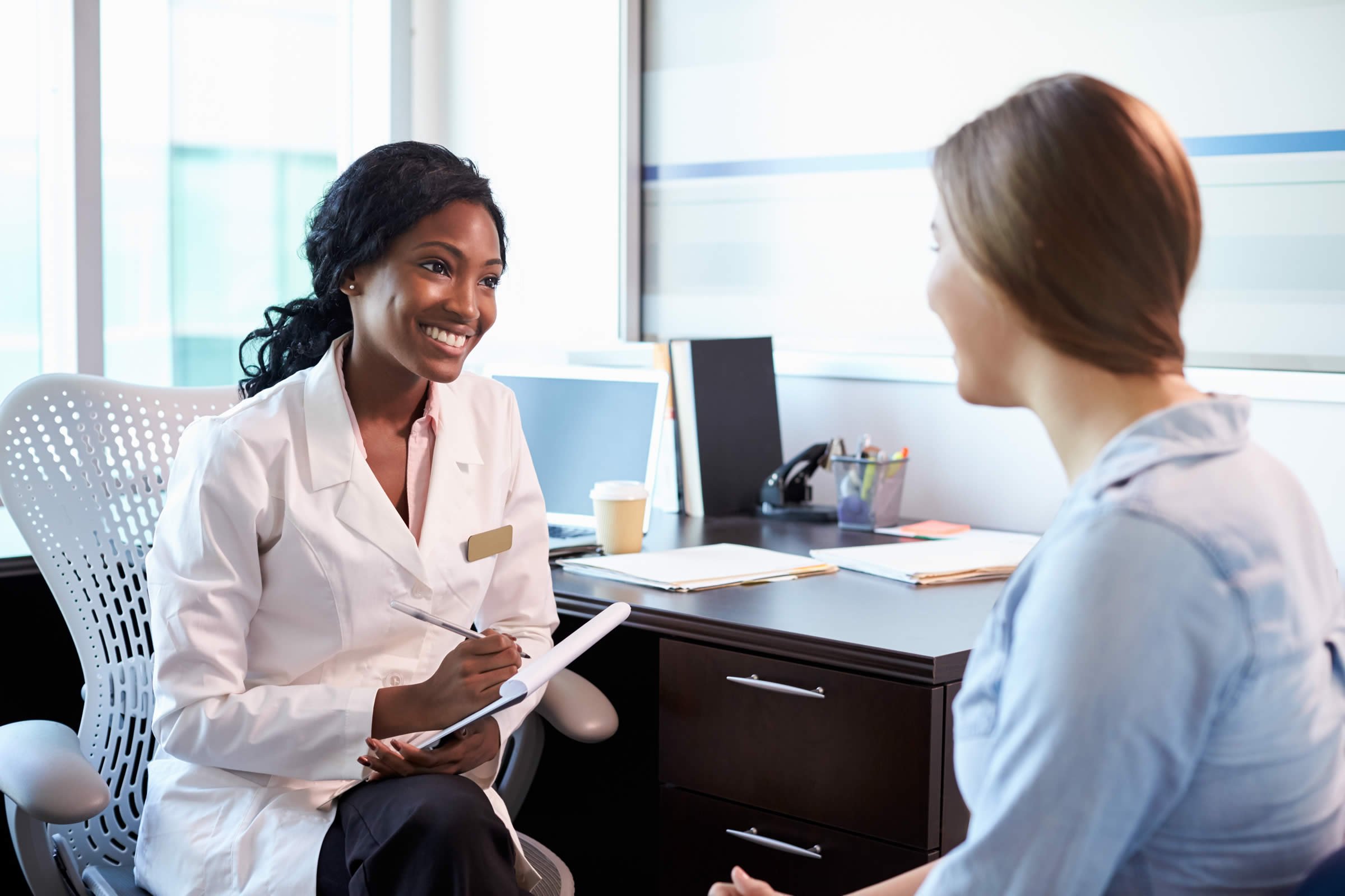 Smiling female doctor with female patient