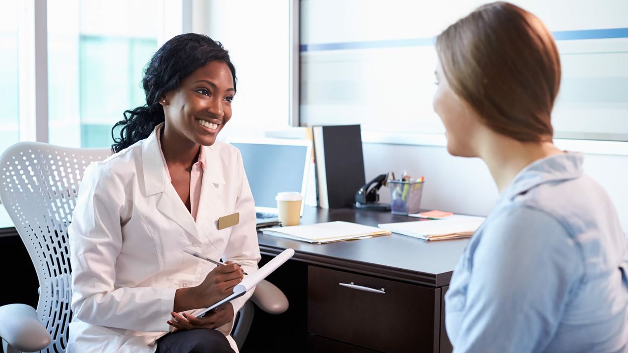 Smiling female doctor with female patient