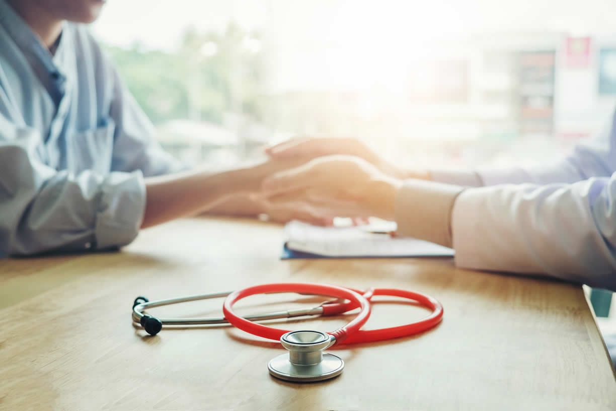 Doctor looking at patients hand