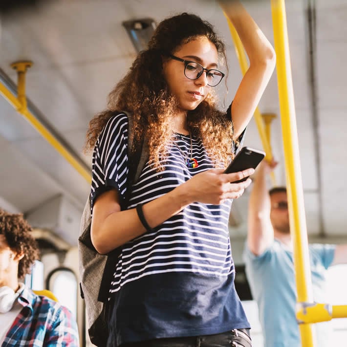 Girl on a bus using mobile phone
