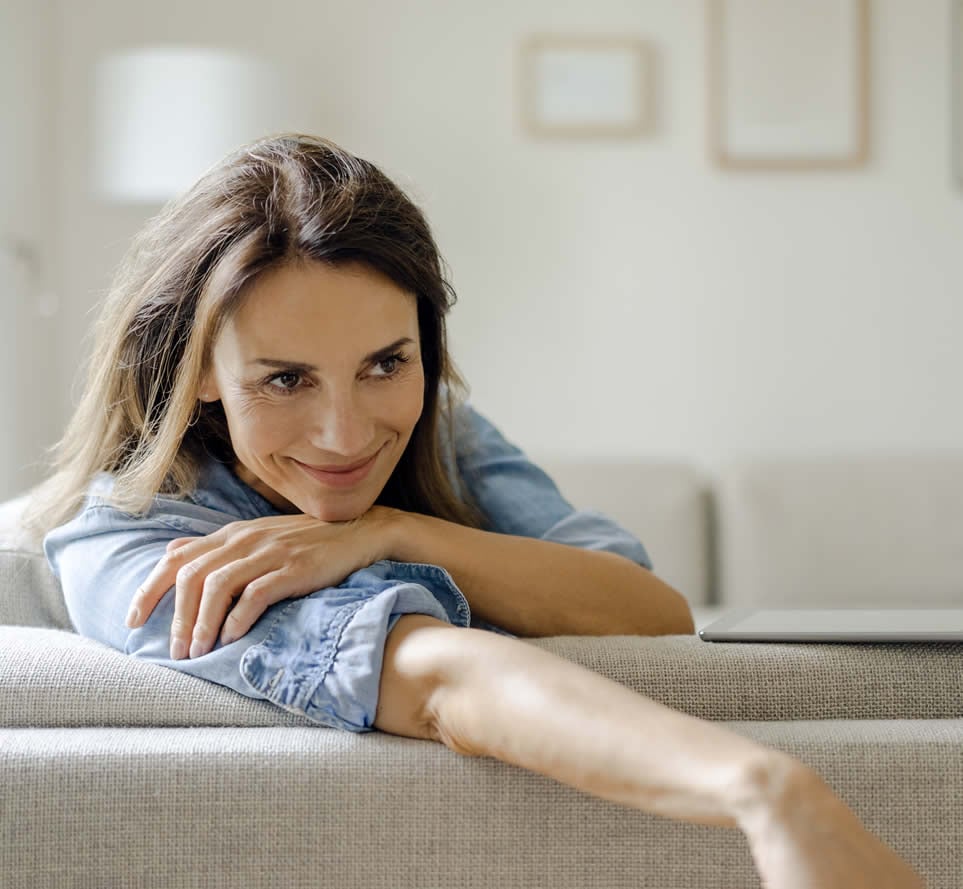 Woman sat on sofa smiling