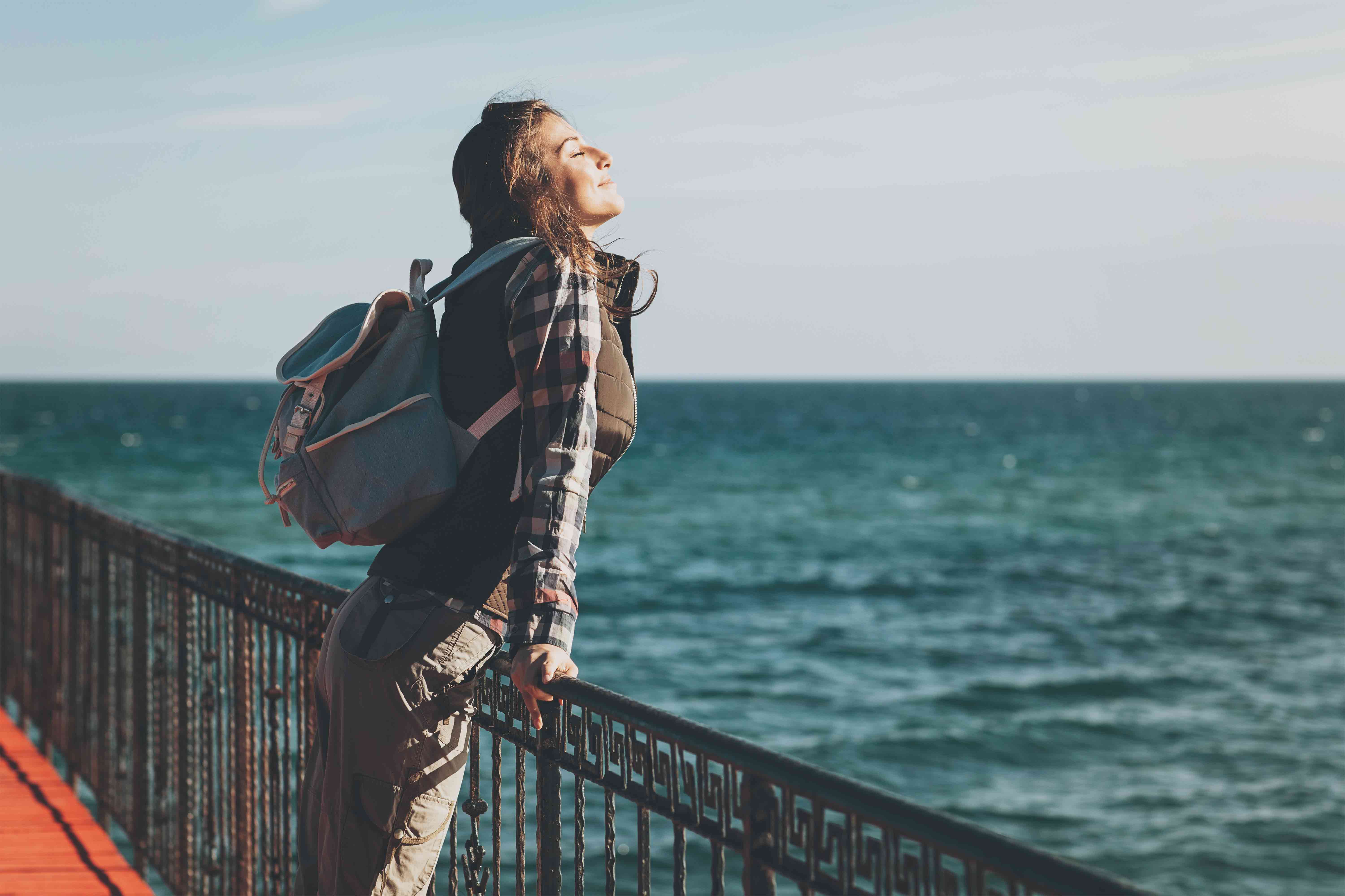 Woman leaning on railing taking in the ocean view