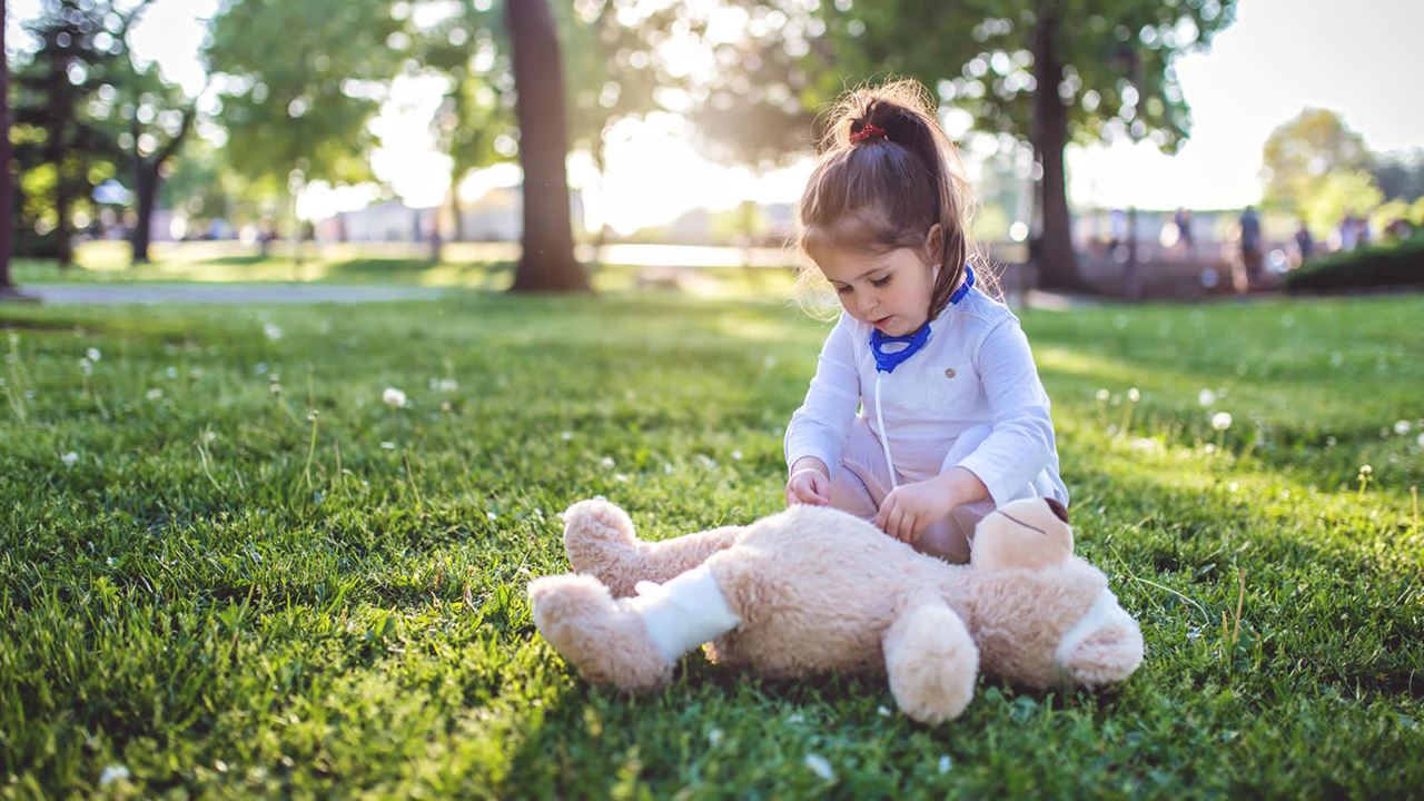 girl playing doctor with teddy