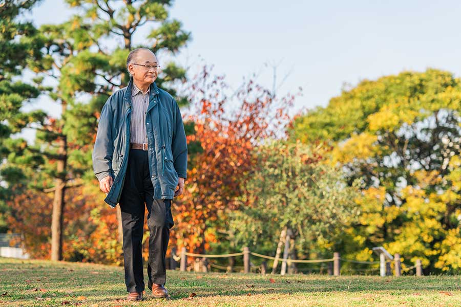 elderly man walking in a park
