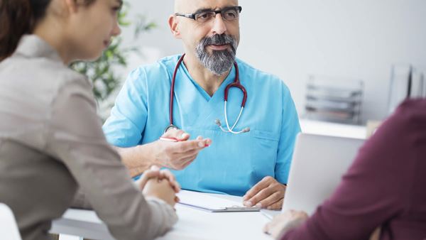 Doctor sat talking with patients