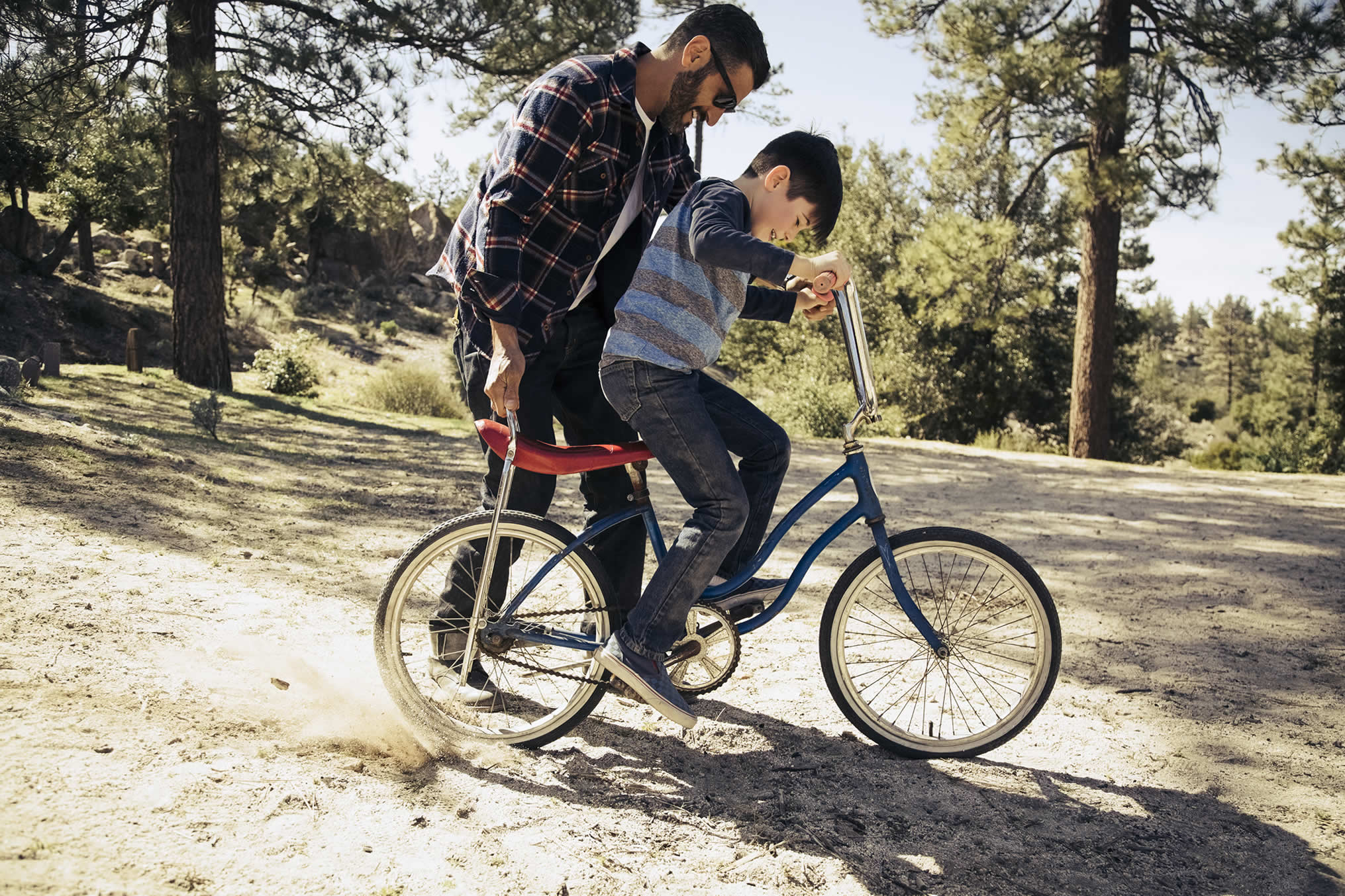 Father teaching son to ride bike