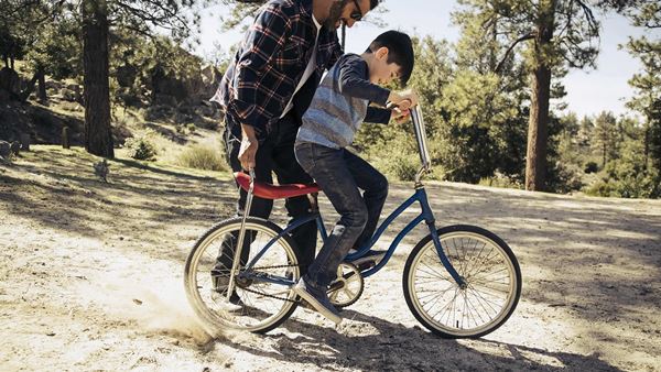 Father teaching son to ride bike