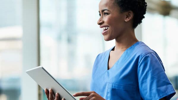 Smiling medical professional using a tablet