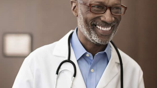 Older male doctor laughing