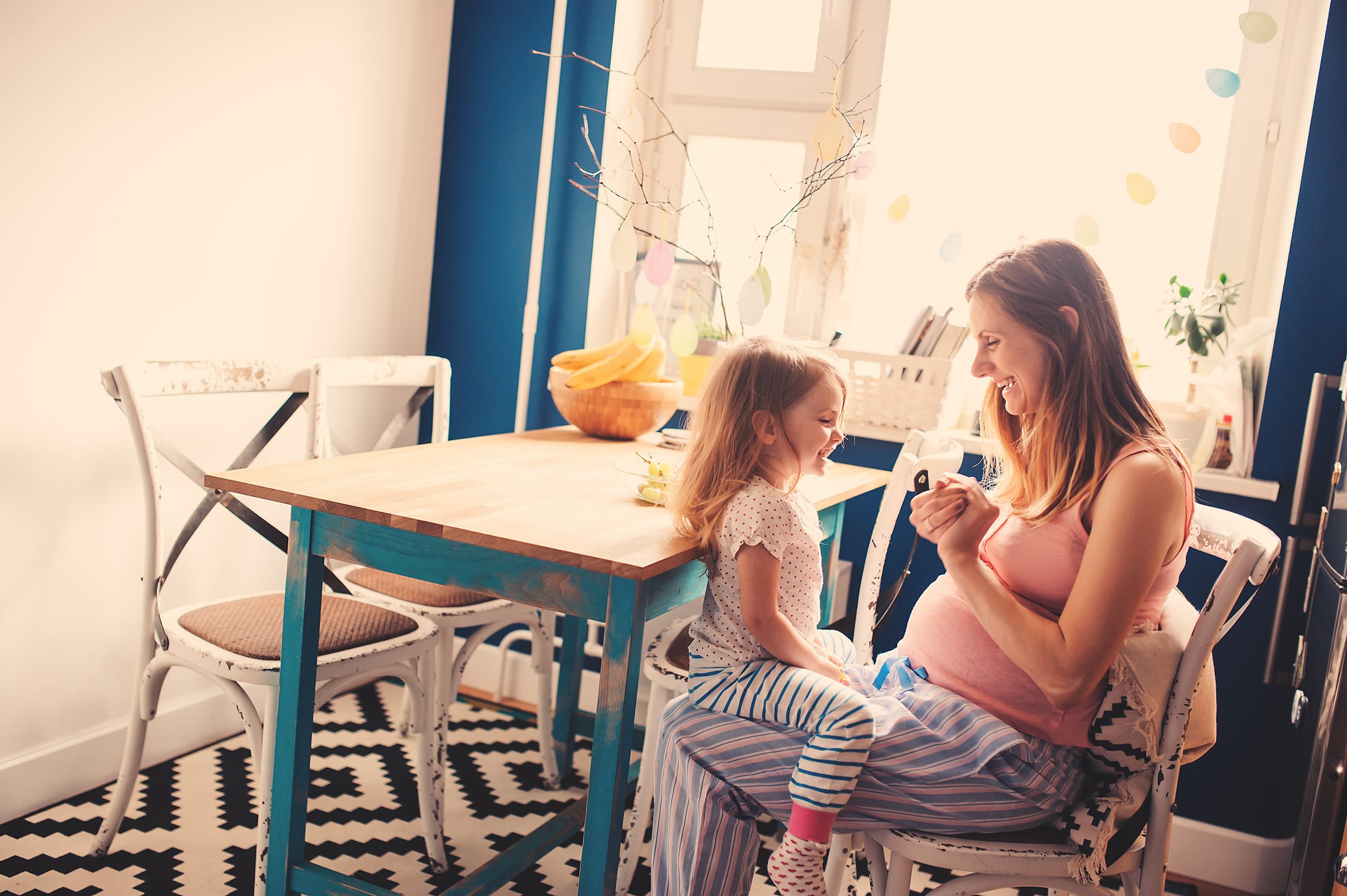 Pregnant mum smiling with daughter