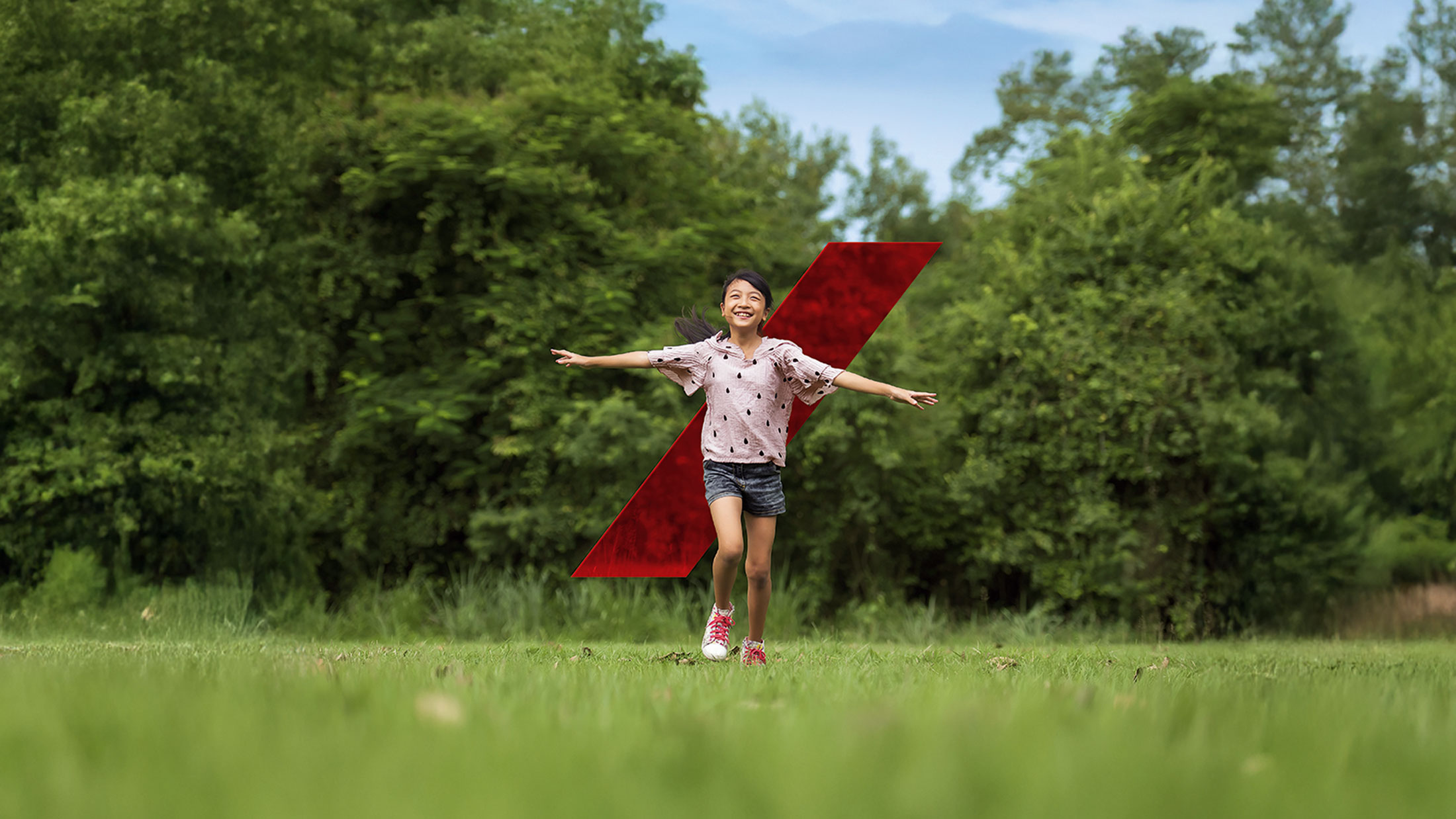 A happy asian girl running on field outdoors