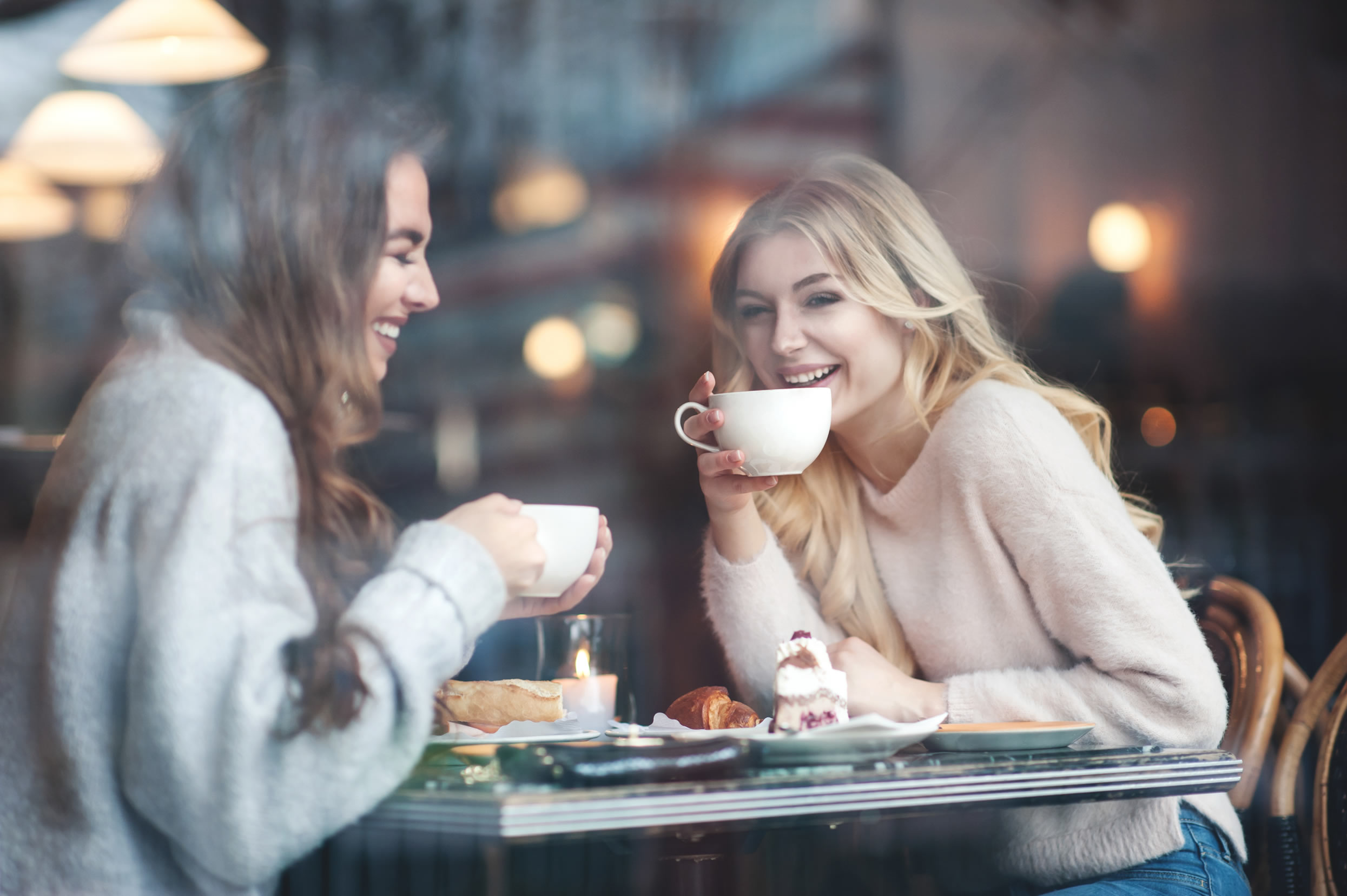 Two women laughing having tea and cake