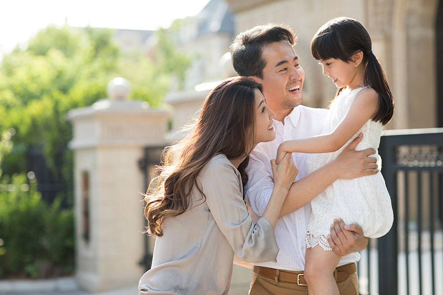 family embracing outside their home