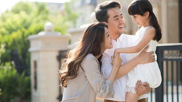family embracing outside their home