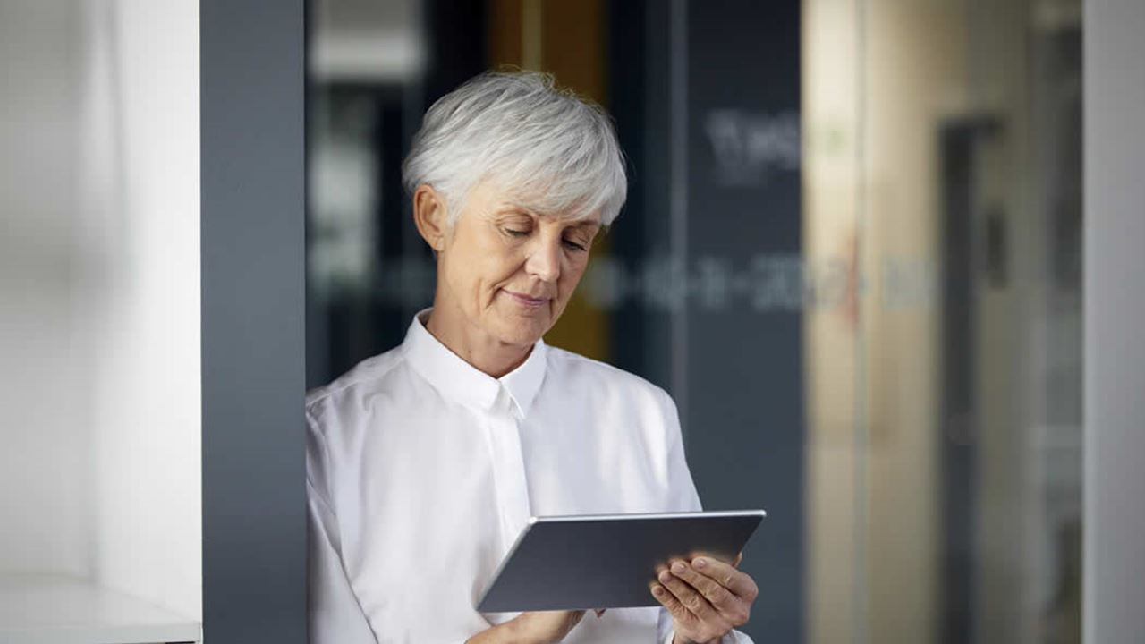 Lady in white shirt looking at a tablet