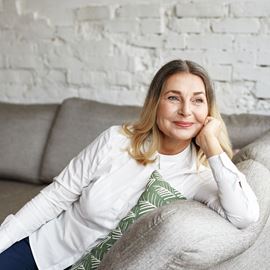 Smiling woman sitting on sofa