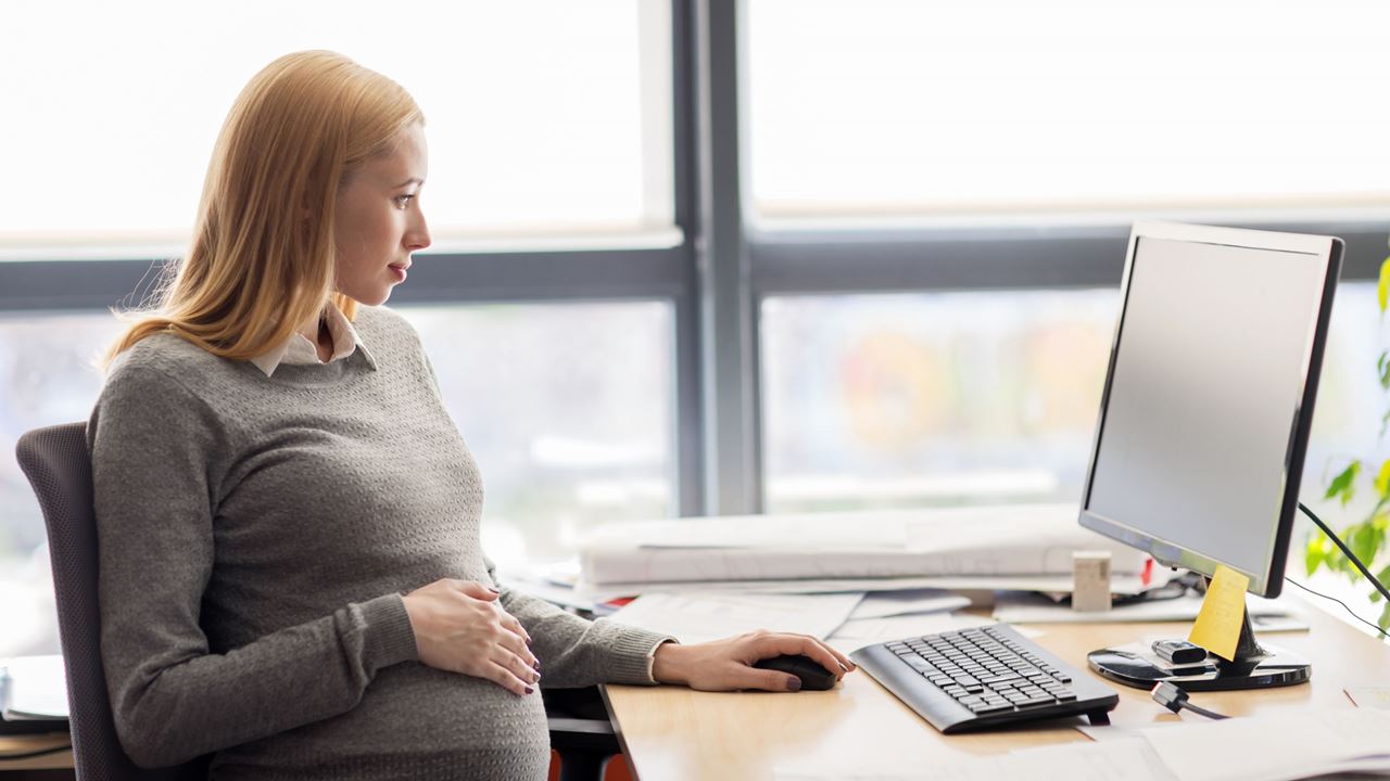 Pregnant woman looking at laptop
