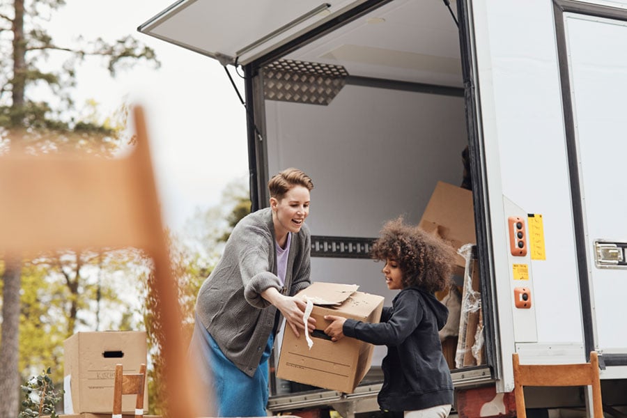 Boy helping mother unload boxes