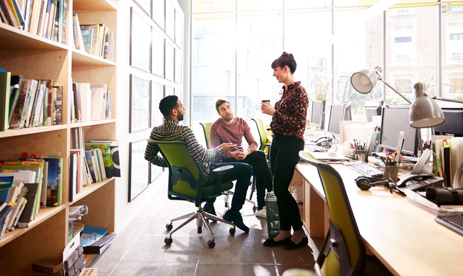 three colleagues chatting in modern office