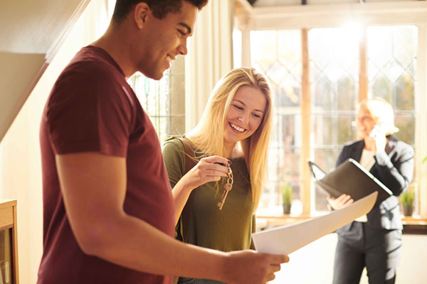 young couple smiling with the keys to their new home