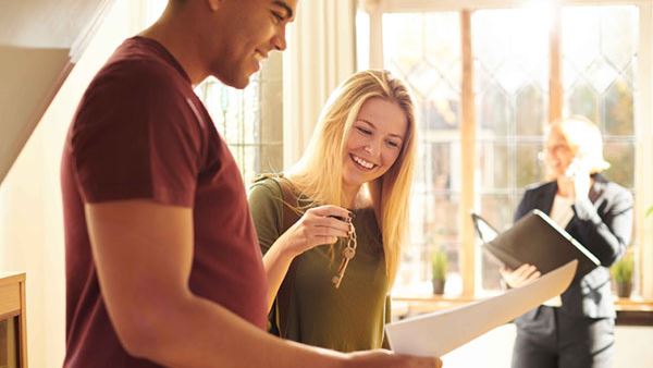 young couple smiling with the keys to their new home